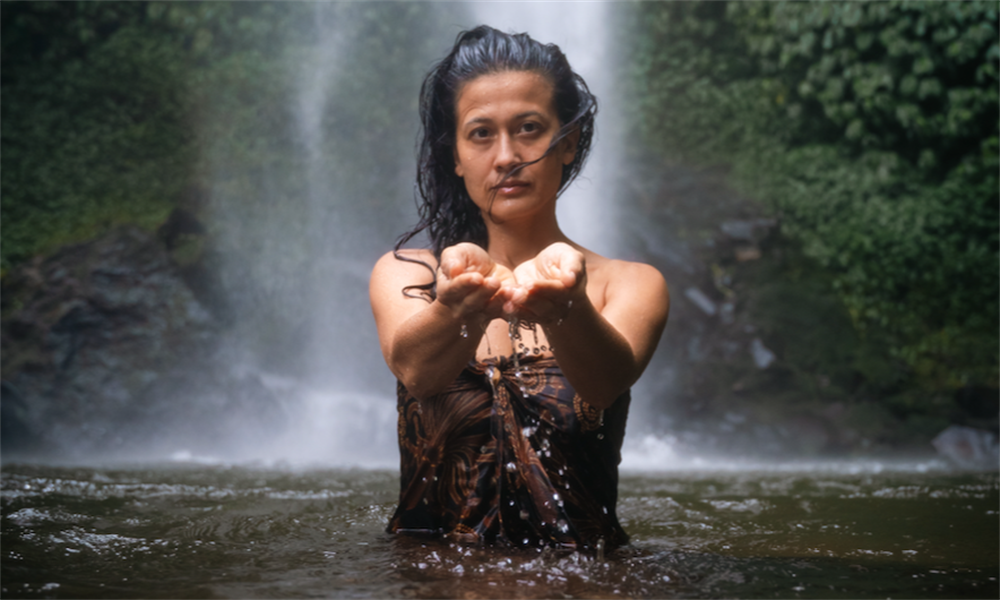 Balinese lady holding water in a natural spring